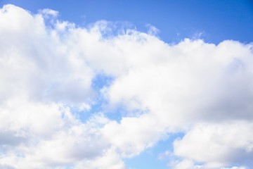 Naklejka na ściany i meble Beautiful white clouds on a sky background. Blue sky with puffy clouds