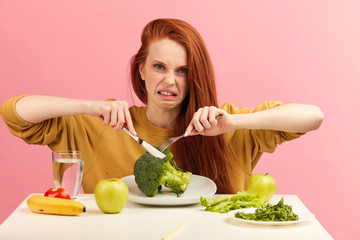 Symptoms of anorexia manifested in aversion to food. Portrait of grimacing unsatisfied facial...