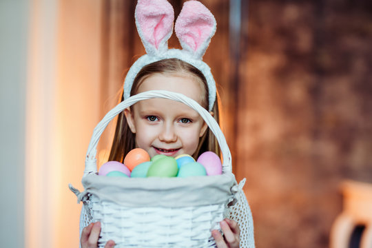 I love to celebrate Easter.Cute girl holding basket with easter eggs and smiling.Celebration concept.