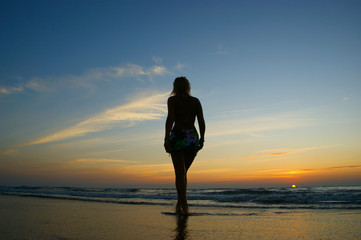 Fototapeta premium walking woman silhouette. women walking on California beach against a colorful sunset