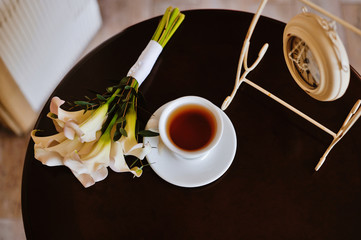 bouquet of hyacinths and tulips, a cup of tea, marshmallows and a heart of lace on a pink background