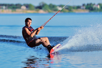 Wakeboarder surfing across a lake