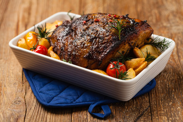 Roasted whole shoulder, with potatoes, peppers and tomatoes. Marinated in white wine.