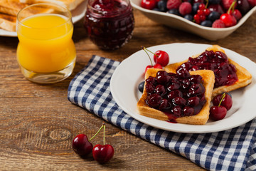 Breakfast. Toasts with cherry or peach jam and fresh fruit.