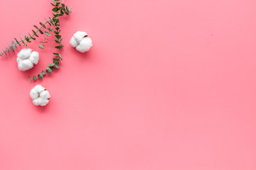 Natural flowers composition with eucalyptus branches and cotton flowers on pink background top view, flat lay copy space