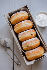 Traditional German Polish Donut with Raspberry Jam Dusted with Icing Sugar. Traditional meal on Fat...