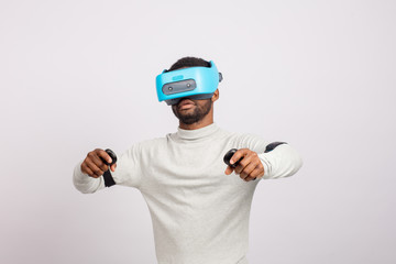 Stylishly dressed african guy using new VR technology headset, learning material and getting knowledge and practice through 3D video glasses. Virtual education concept