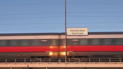amsterdam railway billboard train passing behind train station signboard