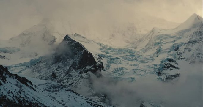 Timelapse of the mountains in Wengen, Switzerland during golden hour, with clouds covering the mountains.