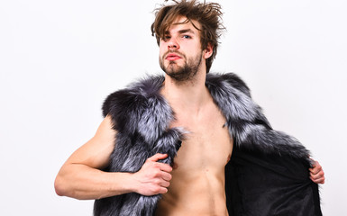 Fashion concept. Fashion and pathos. Richness and luxury lifestyle. Sexy sleepy rich macho tousled hair fur vest on white background. Guy attractive fashion model posing fur coat on naked body