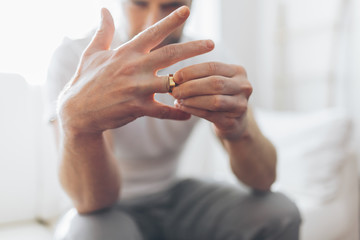 Heartbroken man holding a wedding ring