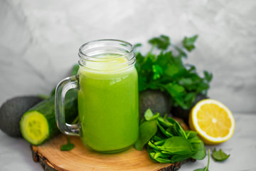 Obraz na płótnie Canvas Green smoothie. Healthy green detox smoothie glass with spinach, lemon, cucumber, lemon and avocado, healthy organic food