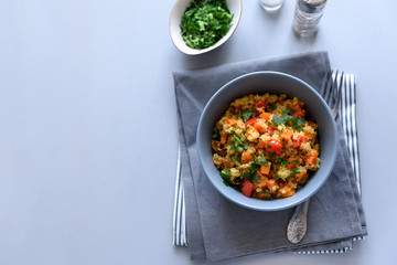 Healthy vegan bowl with quinoa, pumpkin, pepper and carrot on gray wooden background. Selective focus