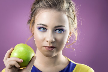 Portrait shot of a beautiful girl with a green apple