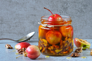 A jar of honey, nuts and paradise apples. Vitamin mixture. Healthy sweets.
