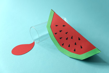Spilled juice and paper watermelon on blue background. Copy space. Creative or art food concept