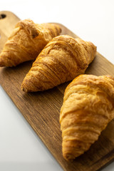 Fresh croissants on wooden board