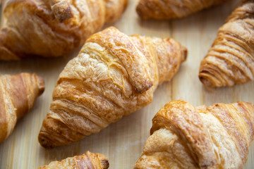 Group of fresh baked croissants on wooden board