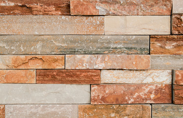 Grunge brown stone wall tiles texture. Wall panel natural brown,orange stone dirty,dust with pattern for architecture and interior design or abstract background.