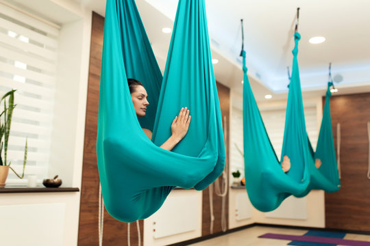 Woman meditation in hammock. fly yoga stretching exercises in gym. Fit and wellness lifestyle