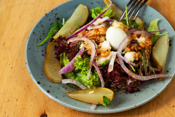 Plate with rich salad (vegetable, nut, cheese, quail egg and pear).