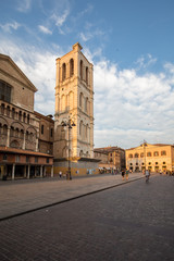 Fototapeta na wymiar Ferrara, Italy - June 10, 2017: Scene of the Piazza Trento e Trieste and the cathedral tower, with local and tourists, in Ferrara, Emilia-Romagna, Italy