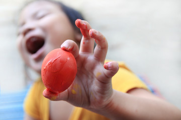  Child show hands holding red Easter eggs, have fun