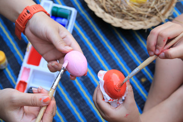 Mother and child hands painted Easter eggs, Art Concept