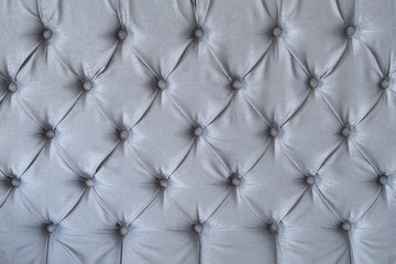 The texture of the surface of a gray sofa with a four-point carriage buttons