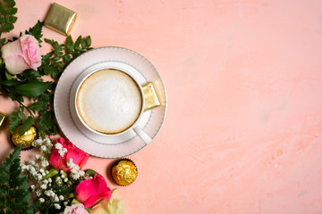 Obraz na płótnie Canvas Cup of coffee with flowers on pink