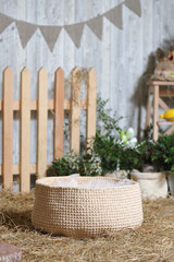 Rustic style decor, woven basket woven on dry hay against the backdrop of Easter decorations