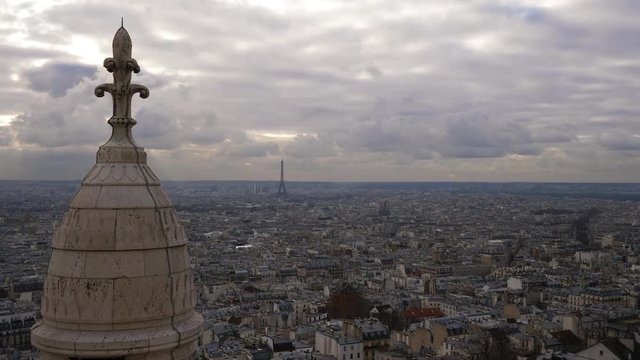 Panning shot of Paris on a cloudy winter's day from the top of Sacre Coeur Basilica with beautiful light rays on the horizon