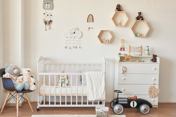wooden toys in the children's room, chest of drawers and a white bed, the interior of the children's bedroom