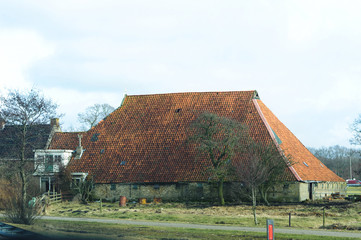 Fototapeta na wymiar Old traditional village house with tiled roof in Netherlands.