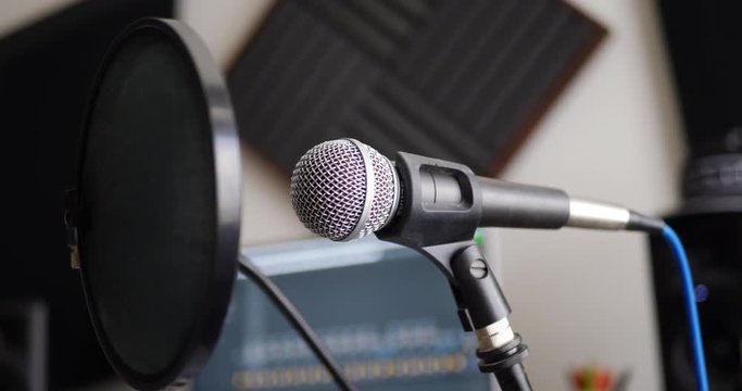 A vocal microphone and pop filter for singing or recording a podcast in a bedroom music studio SLIDE LEFT.