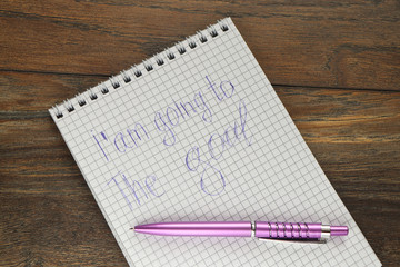  a pen on a notebook with the inscription I'm going to the goal  on the background of a wooden board