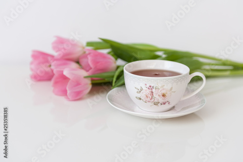 Morning tea with pink tulips on white table. Close up. Soft focus. Spring concept. Happy Mother's Day, Women's Day or Birthday. Minimalism, copy space.