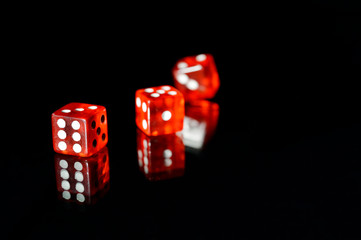 tres dados rojos translucidos en fondo negro
