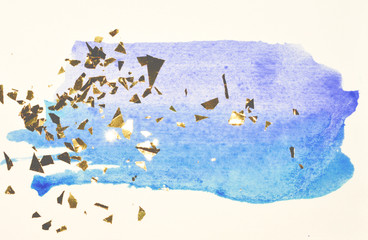 Abstract blue watercolor splash and golden glitter, pieces of foil, background in vintage nostalgic colors.