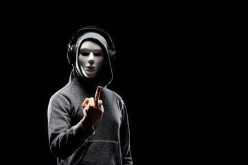Computer hacker in white mask and hoodie. Obscured dark face. Data thief, internet fraud, darknet and cyber security concept.