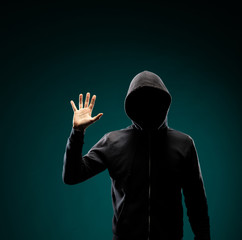 Computer hacker in hoodie. Obscured dark face. Data thief, internet fraud, darknet and cyber security concept.