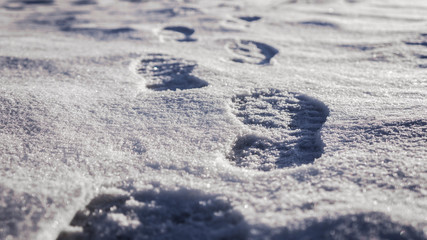 Traces footprints from winter footwear leaving afar on the snow-covered plain