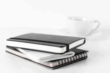 Stack of notepads and coffee, soft focus