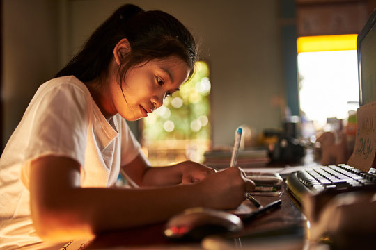 thai teen girl doing homework and studying at home