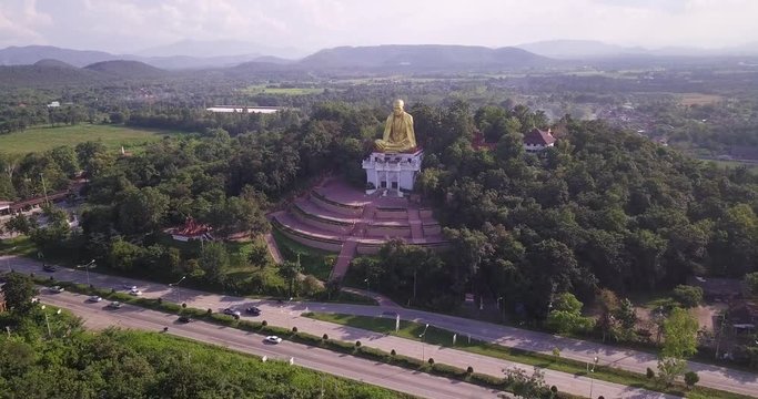 Aerial fly in shot of a famous buddha monument on top of a small hill located in northern part of Thailand.