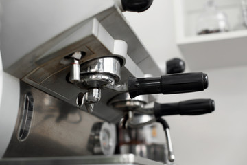 Stainless steel cooking appliance to brew coffee. Parts of coffee machine. Closeup coffee machine holder installed in machine