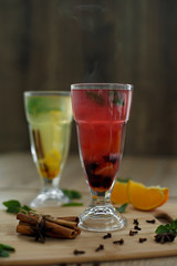 two glasses with colored hot drinks from which steam comes. winter hot seasonal drinks