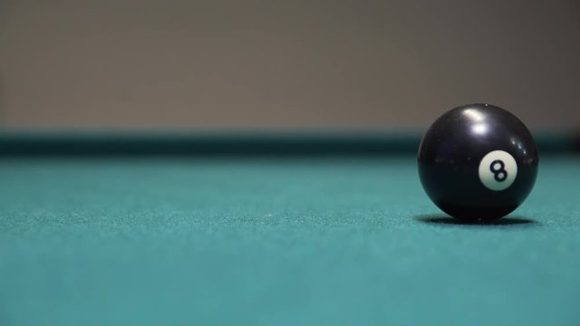 8-ball rolling into frame and stopping on billiards table