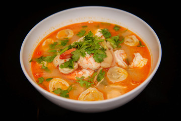 Tom Yum Goong spicy soup traditional food cuisine in Thailand , Top view on black background