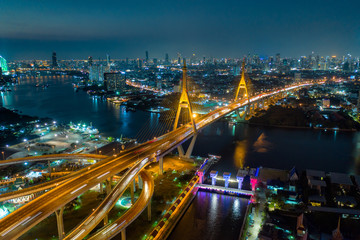 Aerial view of Bhumibol suspension bridge cross over Chao Phraya River in Bangkok city with car on the bridge at night in Bangkok Thailand.